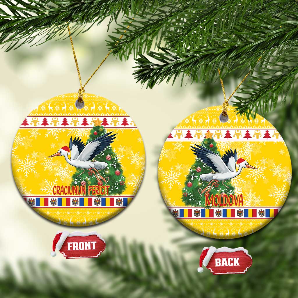 Yellow round ceramic Christmas ornament with stork and green pine tree design.