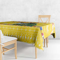 Yellow Christmas tablecloth draped over dining table with chair backs visible