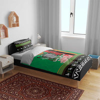 Green and black Christmas bedding set on bed with patterned pillowcases and border detail