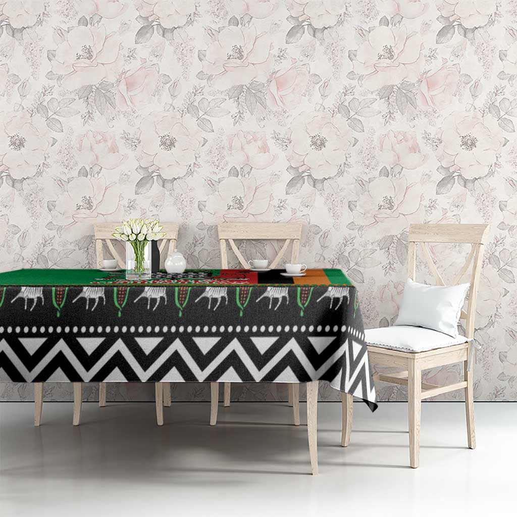 Green tablecloth with black-and-white zigzag animal motif and multicolor patterned edge