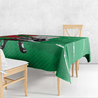 Green tablecloth with wolf warrior grunge print and hanging fabric over wooden chairs.