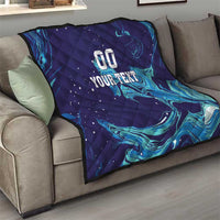 Dark blue quilt draped on a sofa with teal flame waves and “00 YOUR TEXT” in center.
