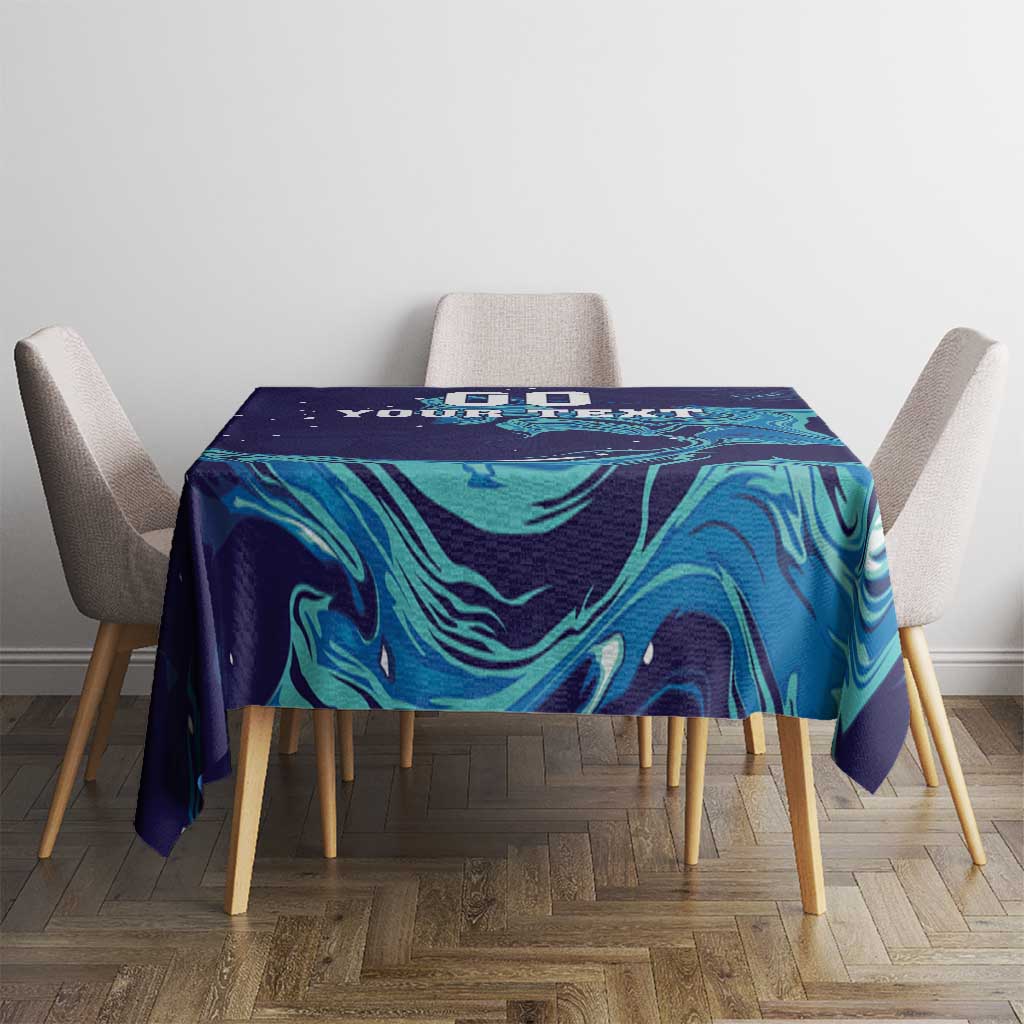 Custom rugby tablecloth on dining table, navy with teal flame-like swirl and “DO YOUR TEXT”