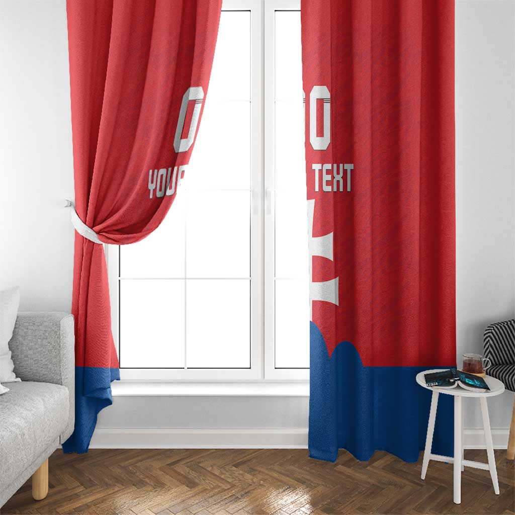 Red and blue flag window curtains with white cross and custom text, one side tied back.