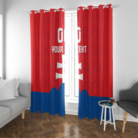 Red window curtains with white cross and custom text, blue bottom stripe on hanging hooks.