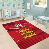 Red area rug with white text and yellow lion crest on patterned background