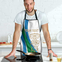 White apron on wearer, blue/green stripes and gold chef emblem; neck and waist straps
