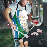 White apron with blue/green stripe panel and gold chef emblem; adjustable neck and waist ties