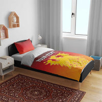 Red duvet with “YOUR TEXT” and yellow coat of arms emblem on bed with pillows