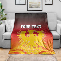 Personalized Germany blanket on gray couch, YOUR TEXT over golden lion crest