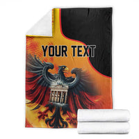 Personalized blanket with “YOUR TEXT” eagle and Berlin Wall art, folded with stacks.