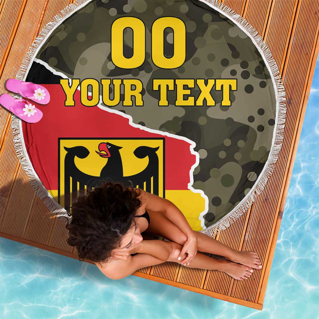 Round beach blanket with fringe edge, camo green with centered red and yellow coat-of-arms