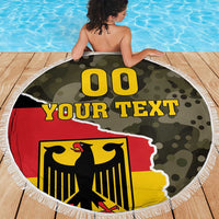 Round beach blanket with fringe edge, green camo background and large coat-of-arms eagle graphic