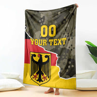 Hanging green camo blanket with Germany crest graphic, red stripe, and “YOUR TEXT”