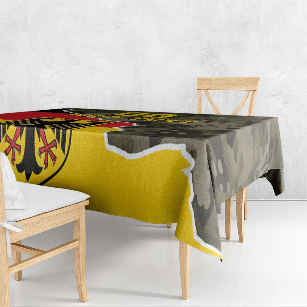 Rectangular tablecloth draped over dining table with bold coat-of-arms and camouflage print