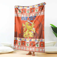 Orange blanket coat with lion crest and 'YOUR TEXT' text over plaid holiday pattern