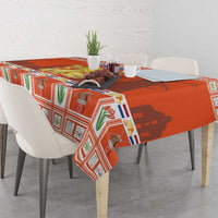 Orange Dutch Christmas tablecloth with coat of arms pattern draped on a dining table.