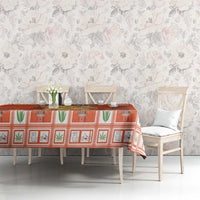 Orange Dutch Christmas tablecloth with coat of arms print across a dining table.