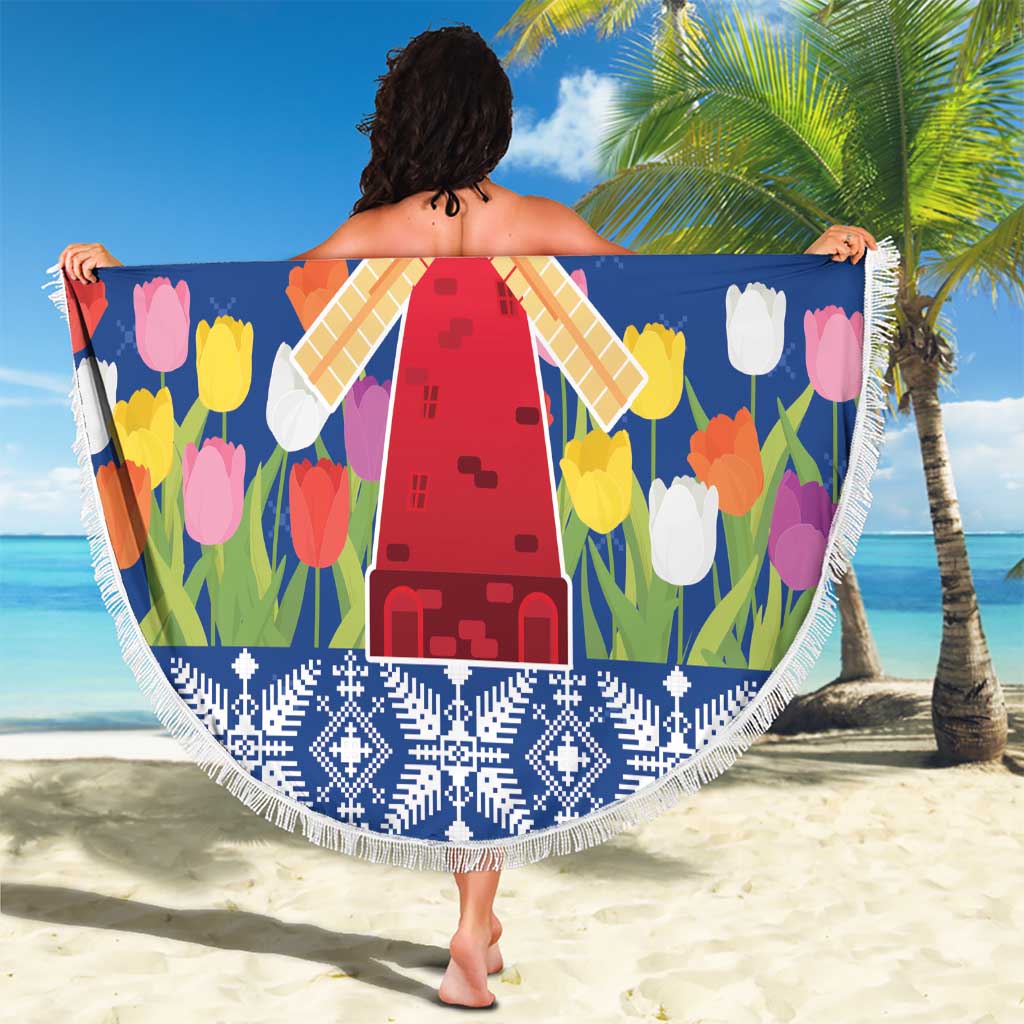Round blue beach blanket with colorful tulip pattern and windmill motif, white tassel fringe