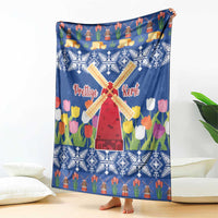Blue Christmas blanket with windmill and tulip flower print, fully spread on the floor.