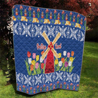 Blue quilt blanket with windmill cross, tulips, and repeating snowflake diamonds.