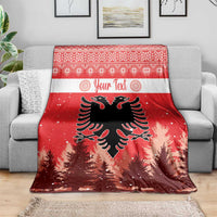 Red double-headed eagle Christmas blanket draped over a gray sofa, pine tree and snow details