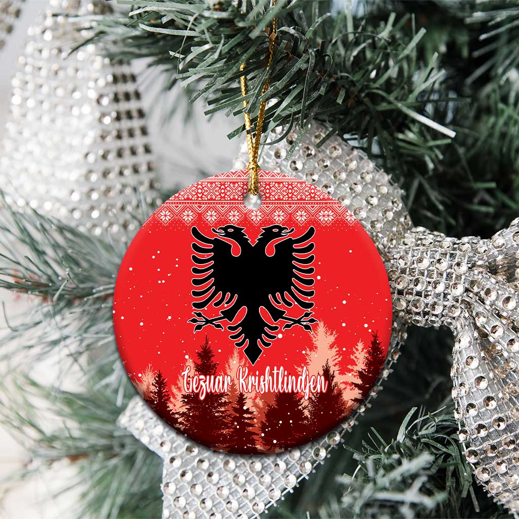 Red ceramic round ornament with double-headed eagle and personalized lettering hanging on tree.