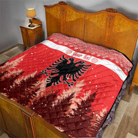 Red and white quilt on a bed with personalized text and Albanian double-headed eagle