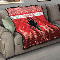 Red and white quilt with personalized text and Albanian double-headed eagle on sofa
