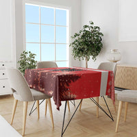 Red Christmas tablecloth draped over dining table, with eagle and snowy forest design