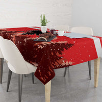 Red Christmas tablecloth on dining table, featuring eagle emblem and pine silhouettes