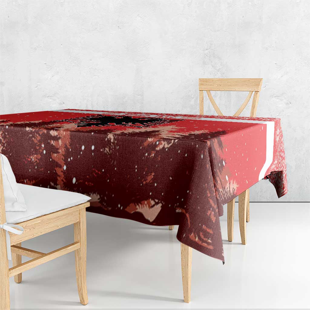 Red Christmas tablecloth corner drape over wooden dining bench, snowy forest motif
