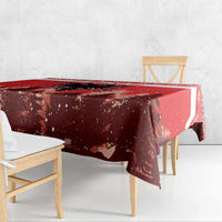 Red Christmas tablecloth corner drape over wooden dining bench, snowy forest motif