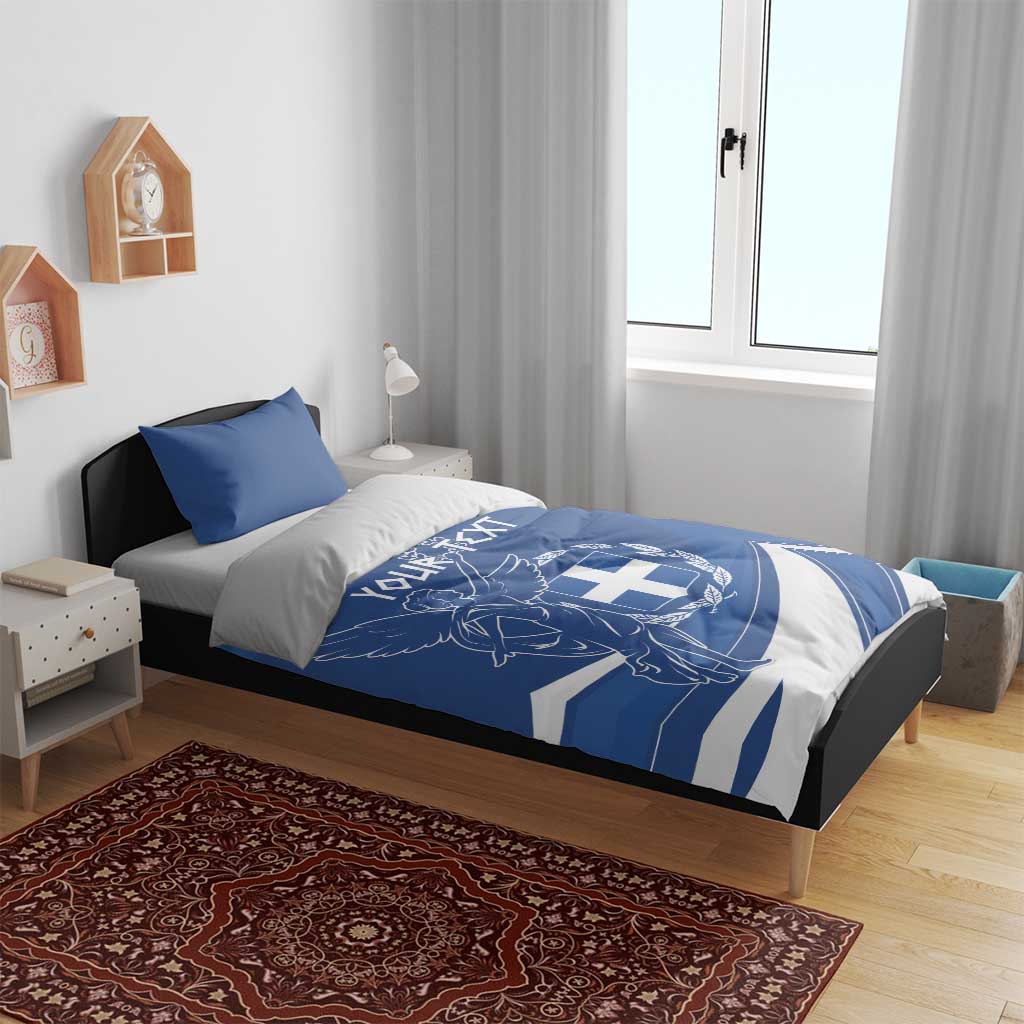 Blue duvet and pillowcases with Greek flag day angel-and-cross emblem, set on bed