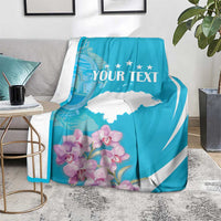 Personalized blue and white throw blanket with 'YOUR TEXT' over chair, floral border