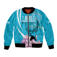 Blue bomber jacket with front graphic of deer, flowers, and striped details; ribbed cuffs