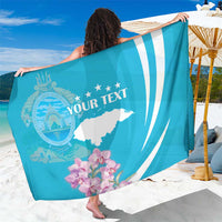 Personalized blue sarong with white wave stripes, circle emblem, orchids, and "YOUR TEXT"