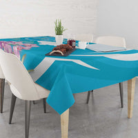 Blue tablecloth with white stripe and purple floral design, spread across a dining table