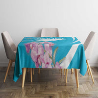Blue tablecloth with white curved stripe and purple flower print across table