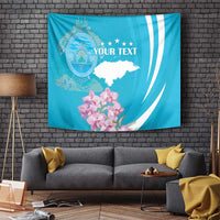 Blue tapestry wall hanging with crest emblem, stars, white map shape, and orchid flowers.