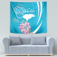 Blue tapestry wall hanging with crest emblem, stars, white map shape, and pink orchids.