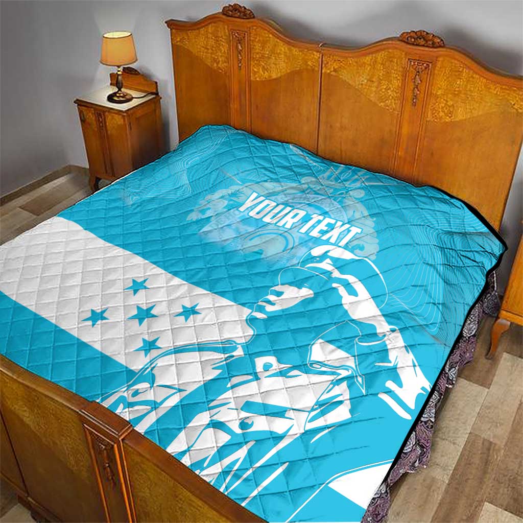 Personalized blue quilt with Honduras bird and stars, on bed with quilted pattern