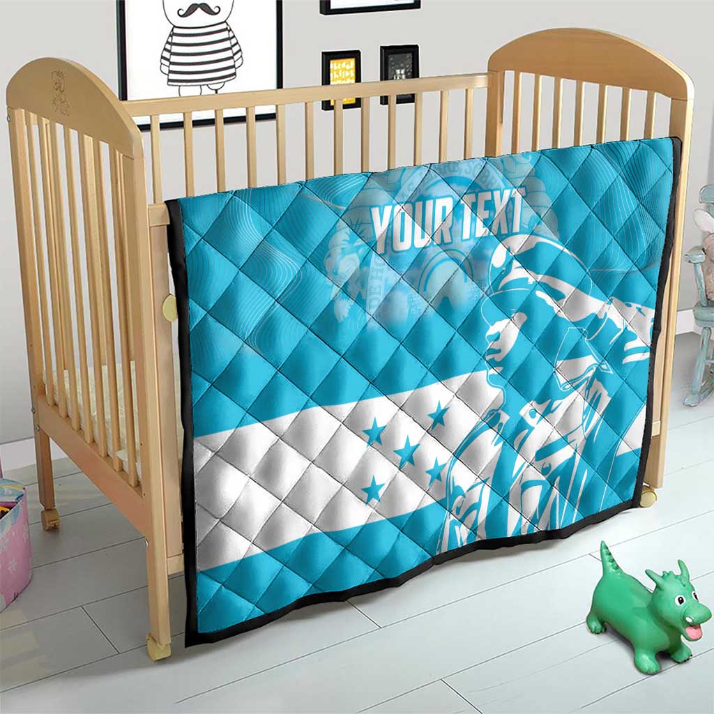 Personalized blue quilt with Honduras bird graphic and star accents, on crib bed