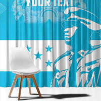 Close view of blue and white window curtain panels with bird artwork, stars, and text
