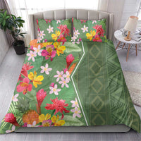 Green duvet and pillow set with tropical blooms in pink, yellow, and red plus patterned side