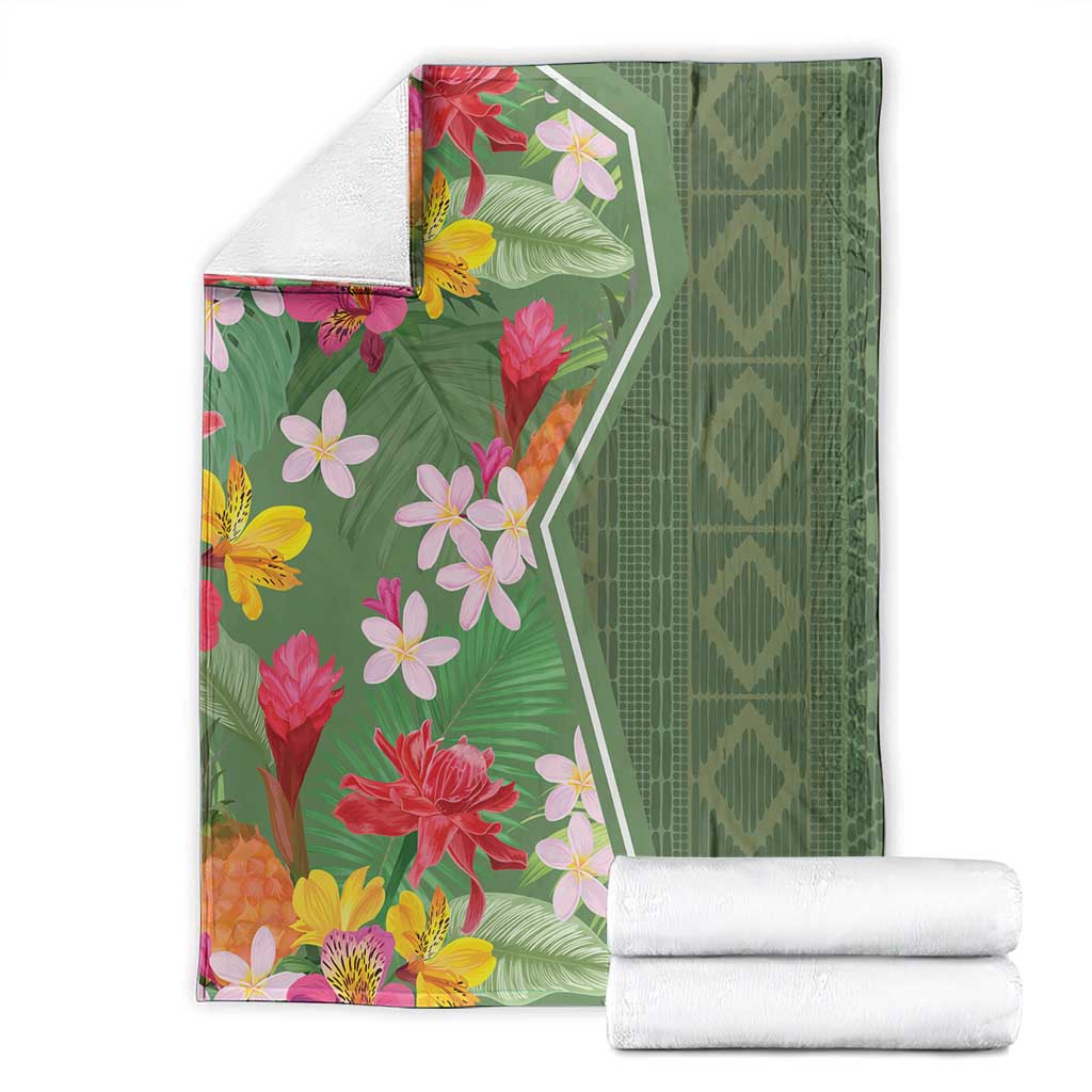 Green tropical flower blanket with stacked white rolls, showing multicolor blooms and border