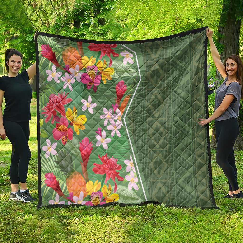 Green tropical floral quilt with multicolor blossoms and quilted diamond pattern on green side