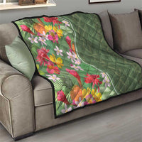 Green tropical floral quilt on couch, bright flower panel with solid diamond-quilted green back