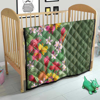 Green tropical floral quilt on a crib, multicolor blossoms with quilted diamond green panel