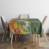 Green tropical floral tablecloth covering square dining table, full front view